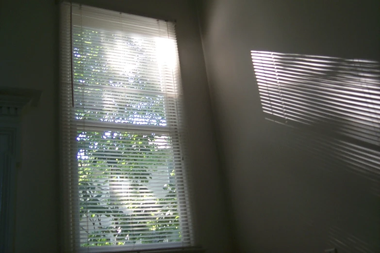 a window with light coming through the blinds