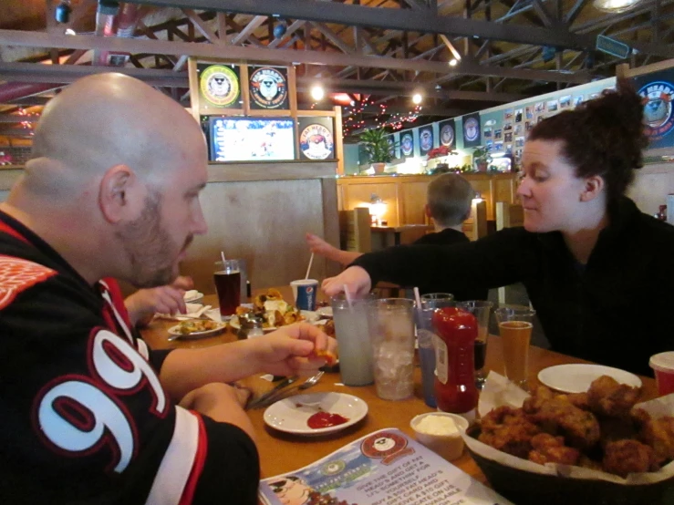 a man and a woman sitting at a table eating food