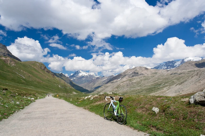 a mountain side dirt path with a bicycle resting on the trail