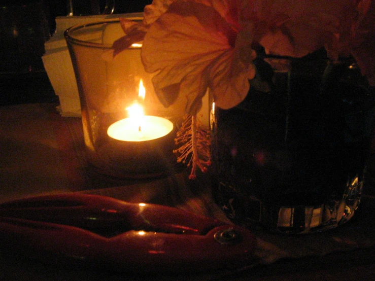 a candle sits on a counter next to a vase with a flower