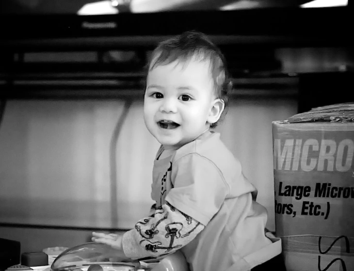 a little baby standing and smiling at the camera