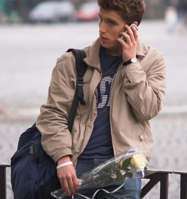 the man is on his cell phone holding a bouquet