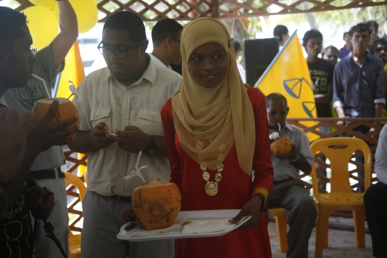 a girl in red is holding a tray of food