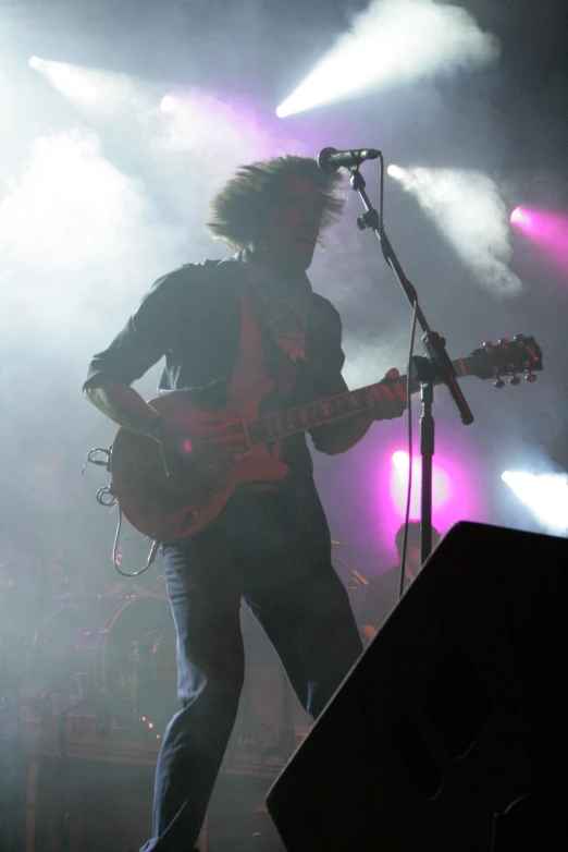 a person standing on stage with an electric guitar