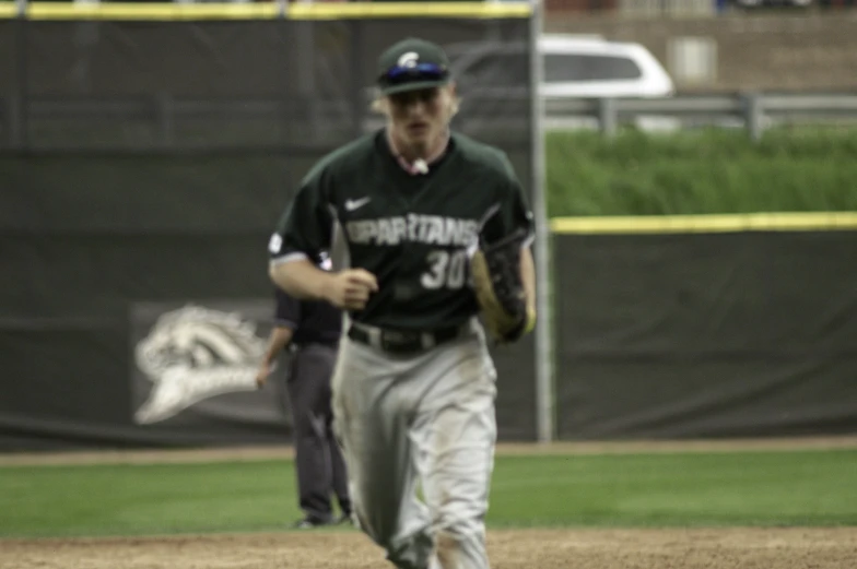 baseball player running on a base to a ball