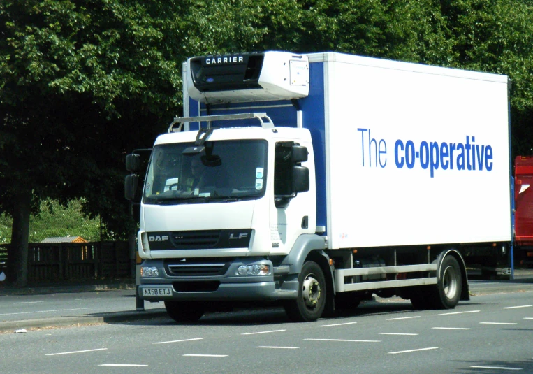 the cooperative box truck is parked on the road