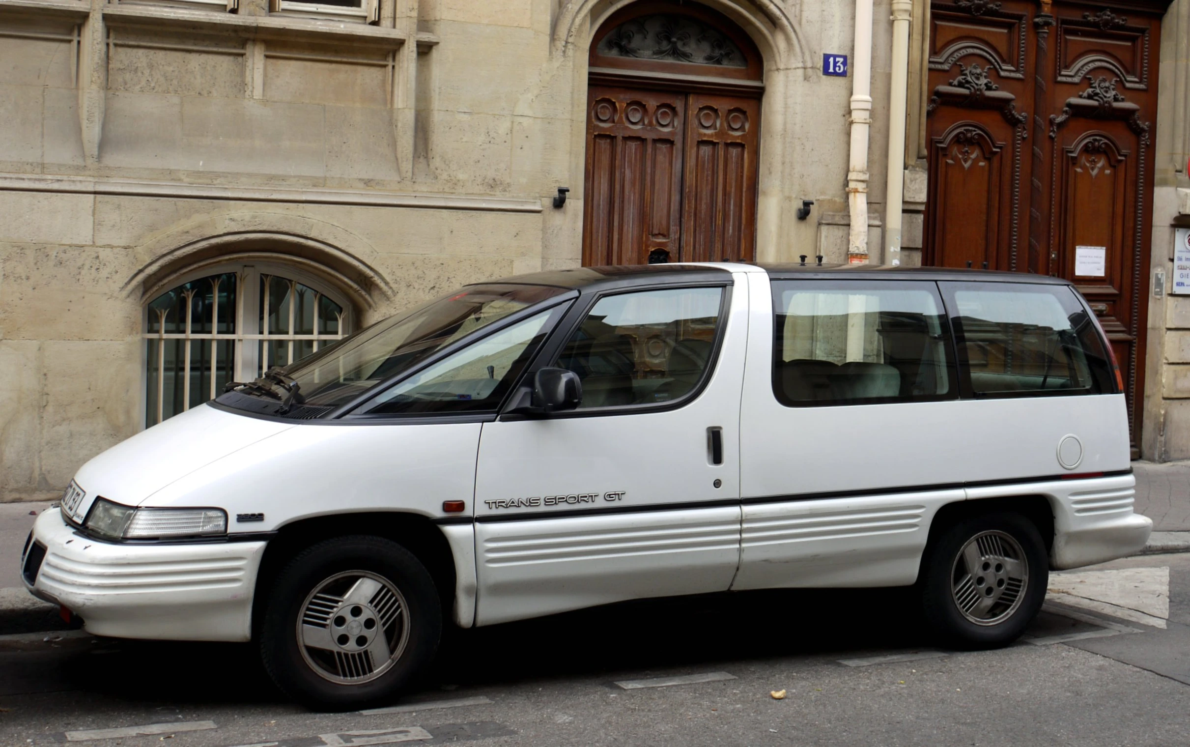 an older white bus parked on the side of the road