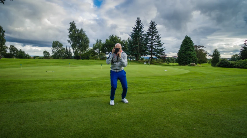 a man standing on top of a green golf field