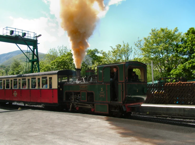 an old - fashioned train is near a river with boats