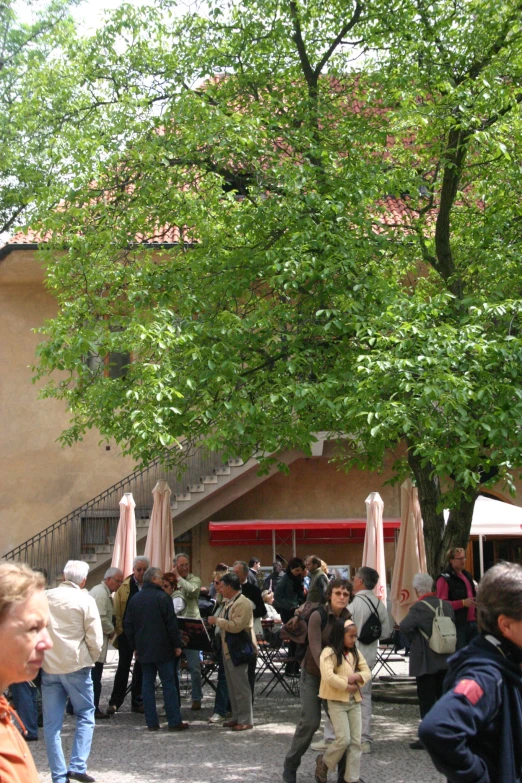 an open courtyard with people standing around eating outdoors