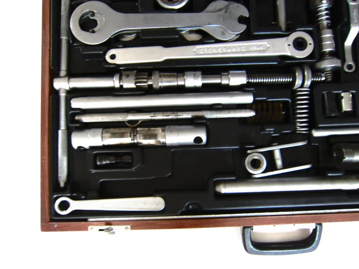 some assorted tools and their contents laid out in a wooden box