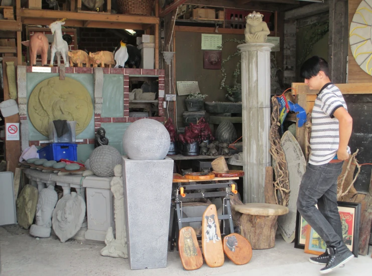 a man looking at a sculpture inside of a shop