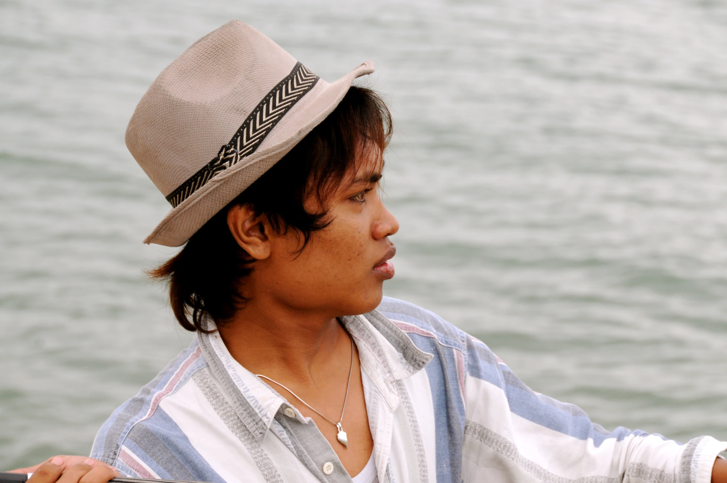 man sitting on boat holding out soing to camera