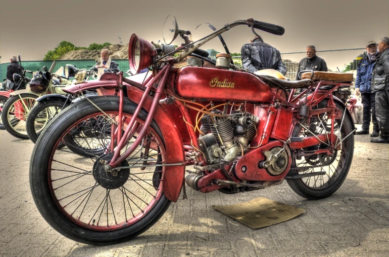 a vintage red motor bike on display in front of a group of people