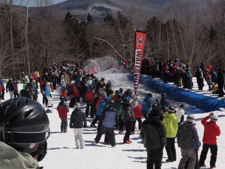 crowd of people gather for an event to start at the bottom of a mountain