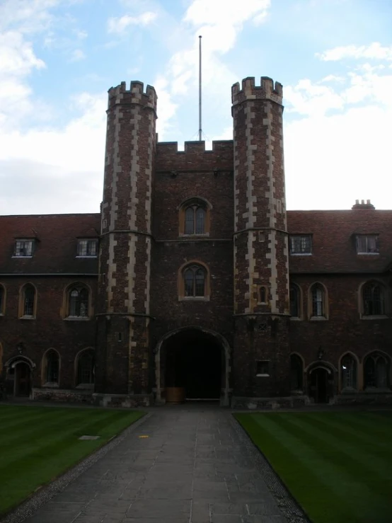 a large castle like building with a big doorway and a green lawn