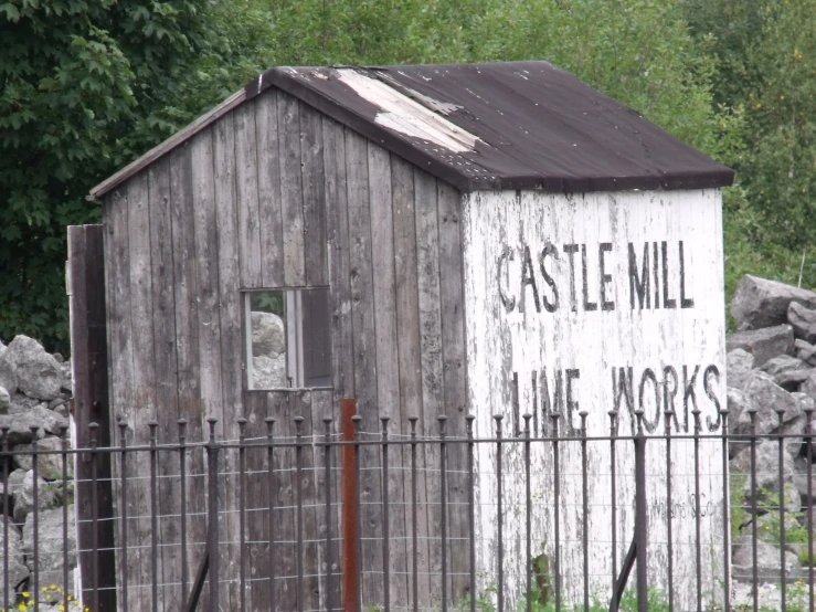 a wooden shed with a sign that reads castle mill in front