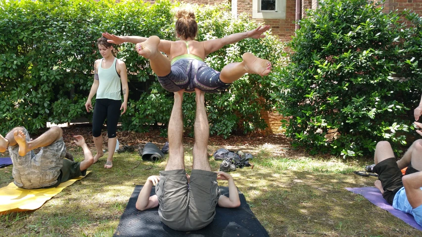 several people doing yoga in the yard on mats