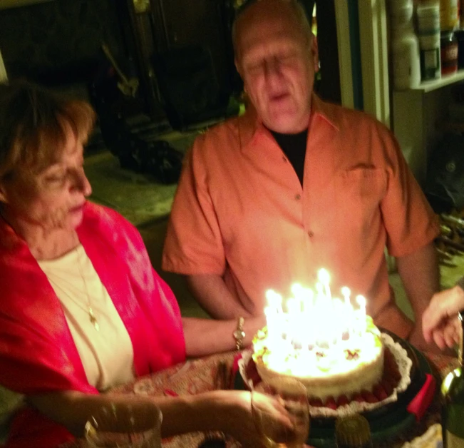 two people with cake lit in the dark