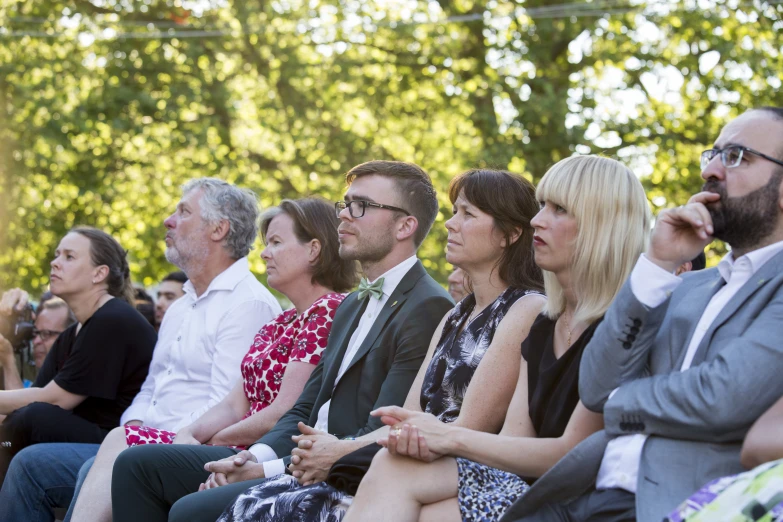 people sitting together with their faces close to one another