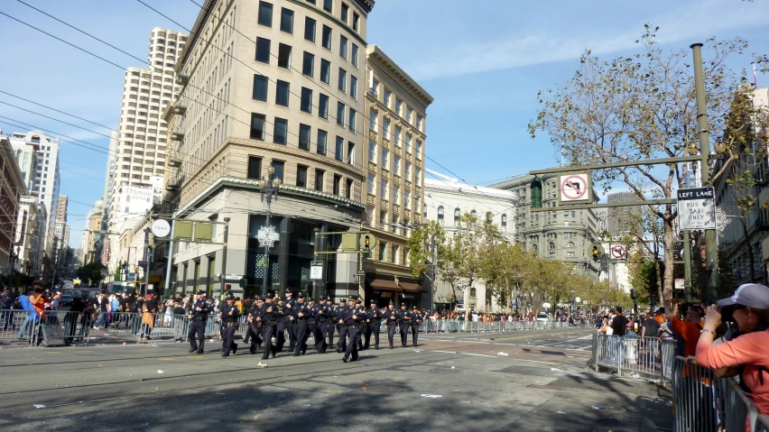 people in uniform walking on the street near tall buildings