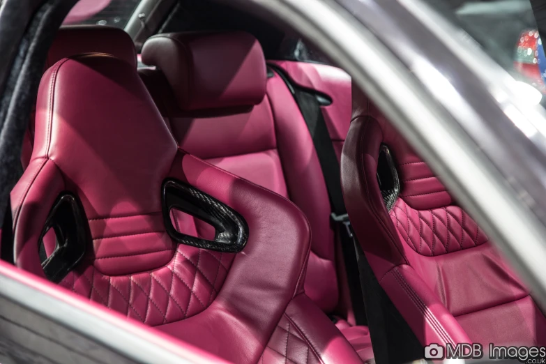 the car interior has pink leather on the seats