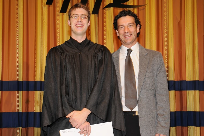 two men in suits standing side by side