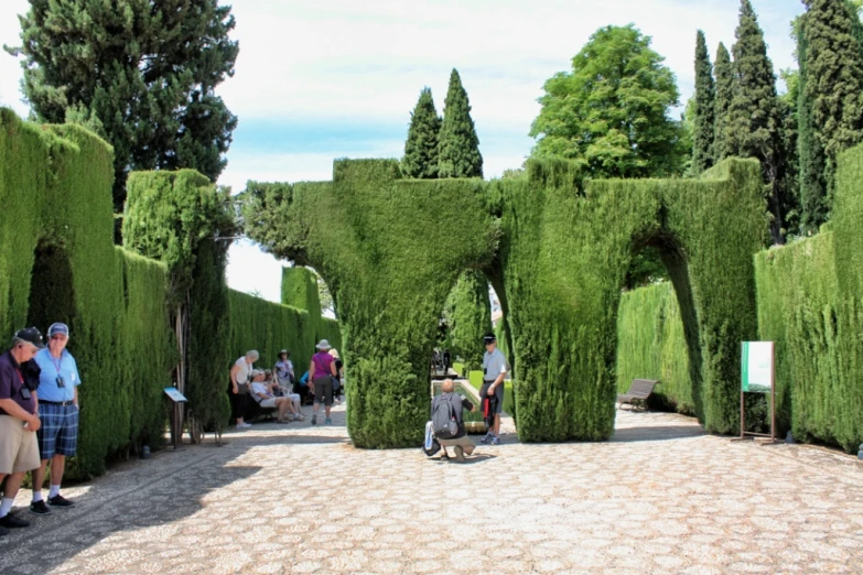 people walking around in front of an art sculpture