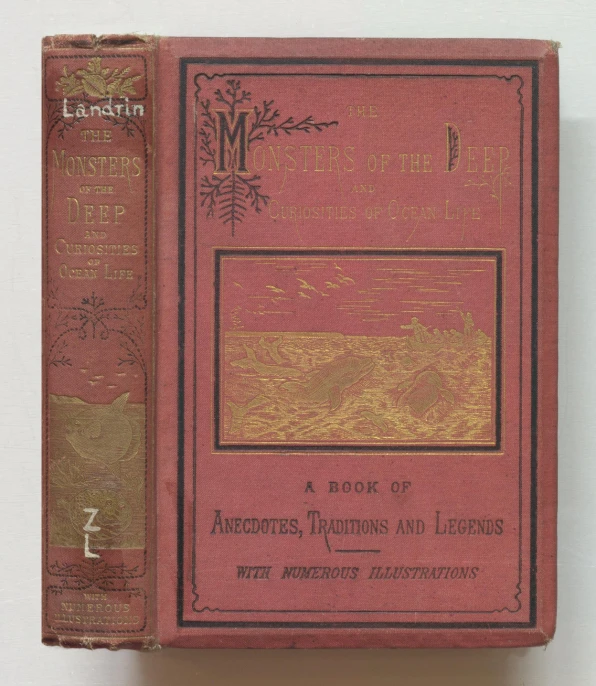 an old red book with gold detailing is next to a white background