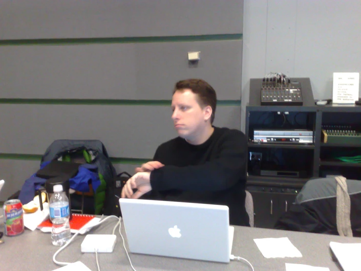 a man sitting down in front of a laptop