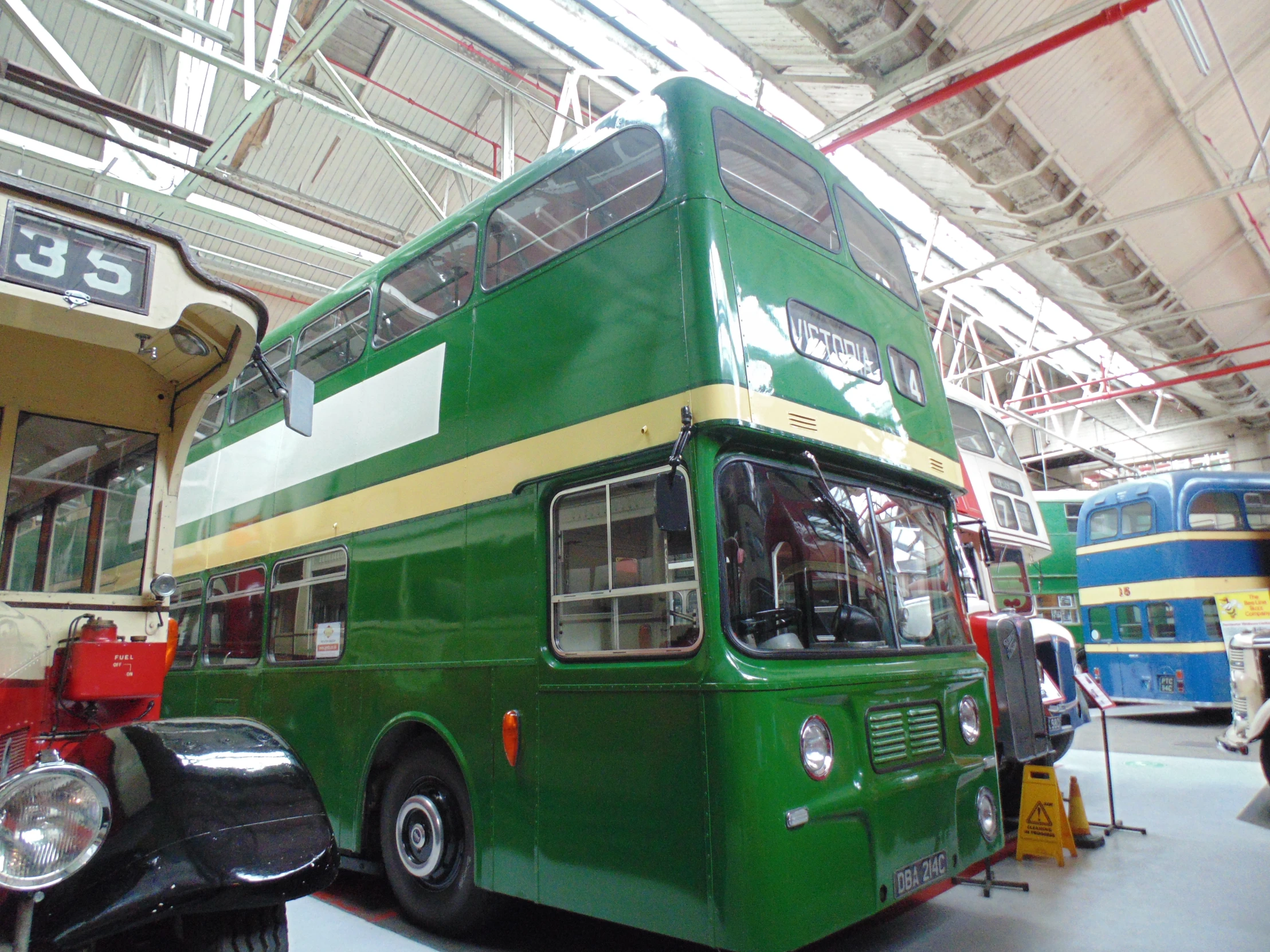 an emerald green double decker bus parked in a building