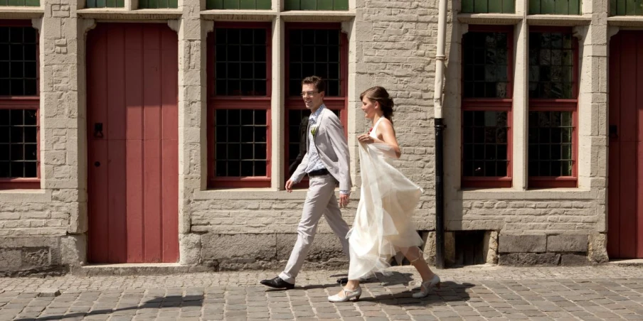 a bride and groom walk in front of three doors