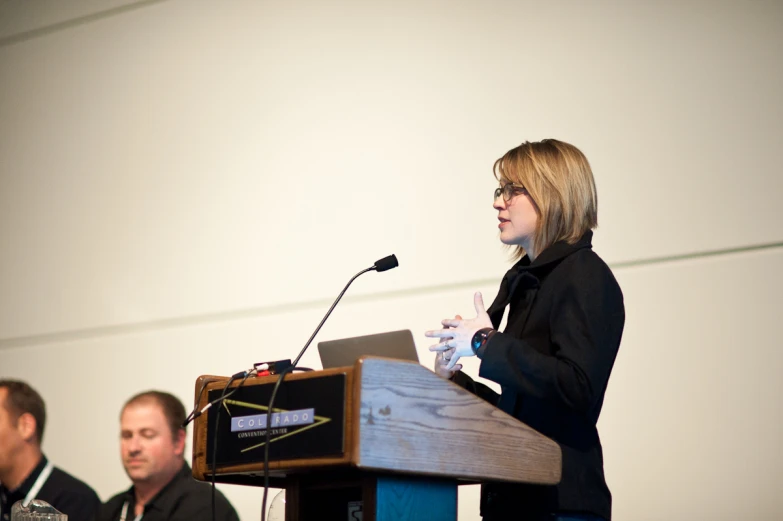 a woman speaking in front of some people