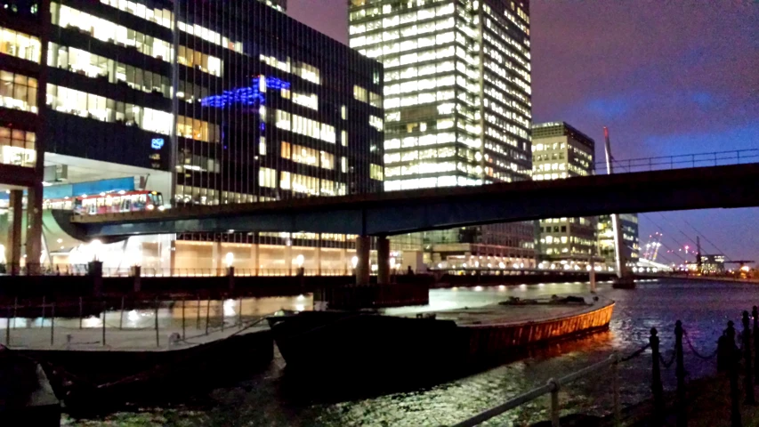 a boat sits on the water below skyscrs