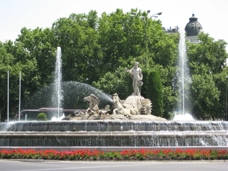 a fountain of water with a large statue in the background