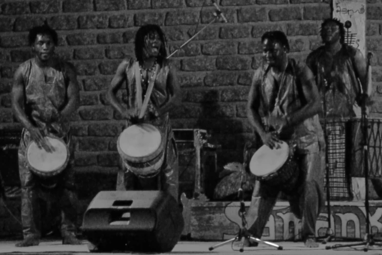 a group of men in native garb with drums