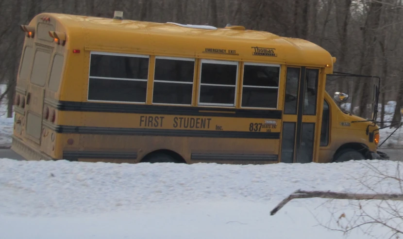 a school bus driving through a snow covered forest