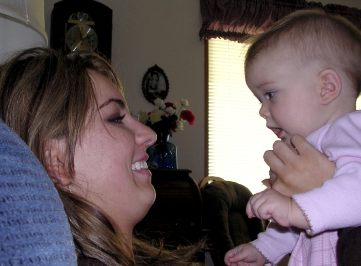 a  smiles while her mother looks at her