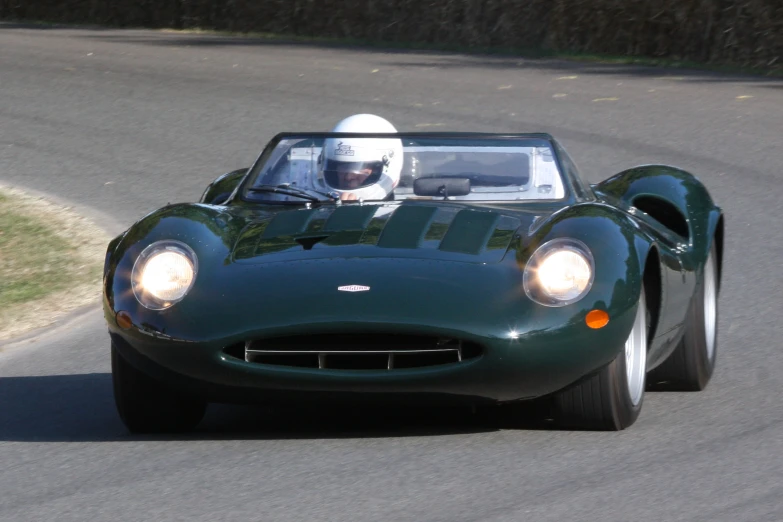 the green sports car is riding down the road