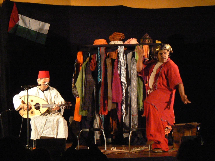 a man playing the guitar while another plays a mandolin