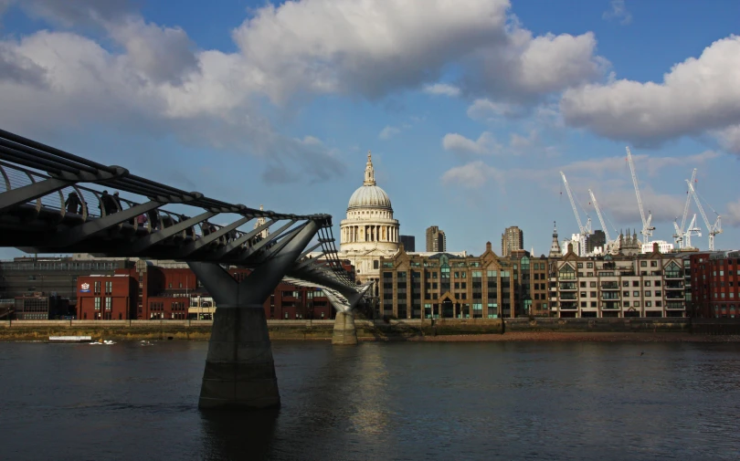 a bridge with a tower and some buildings in the background