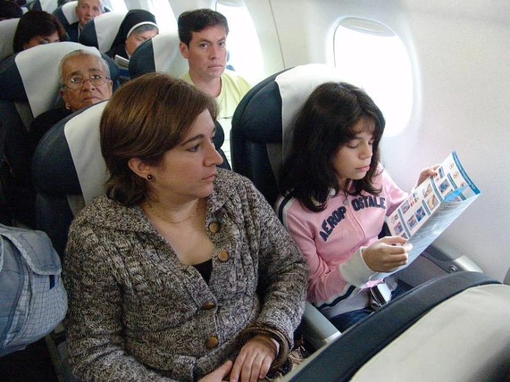 two children and an adult in a passenger plane