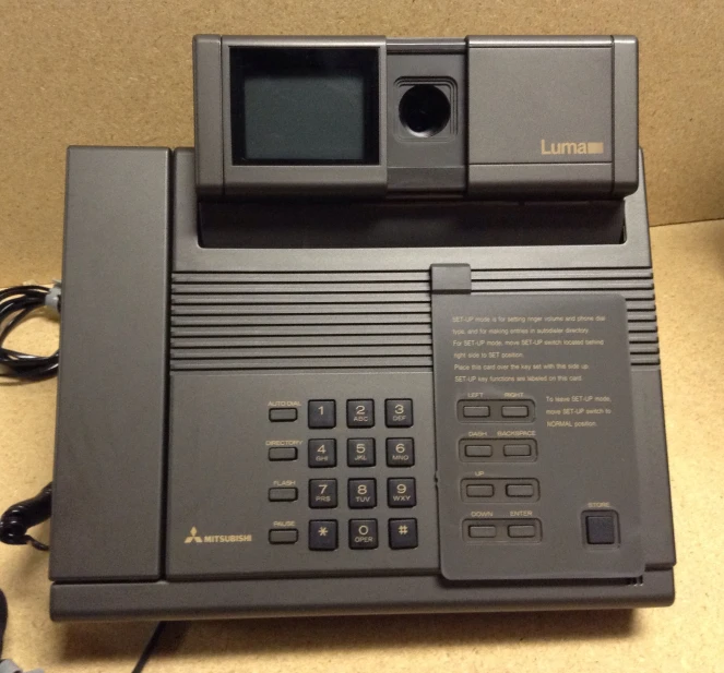 an old office phone sitting on a desk