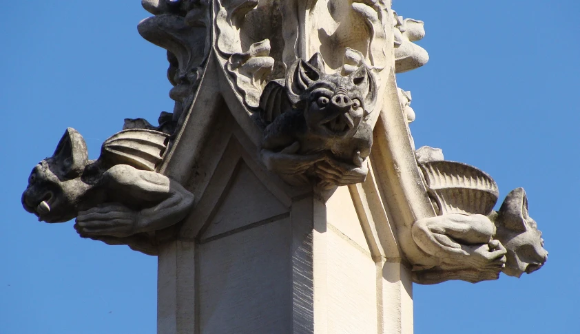 a column with some gargoyle decorations on the top