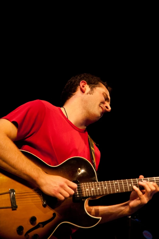 a man that is playing a guitar with a microphone