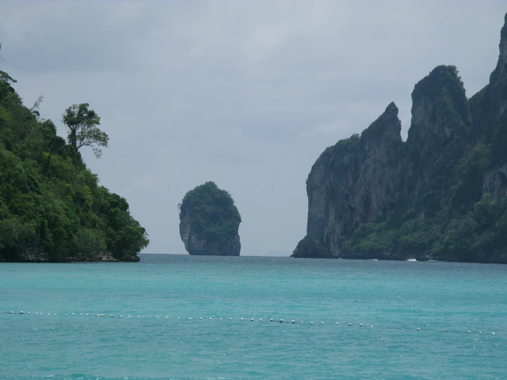 the blue water has three rock islands on each side