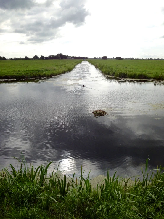 an empty waterway is in the middle of a wide open field