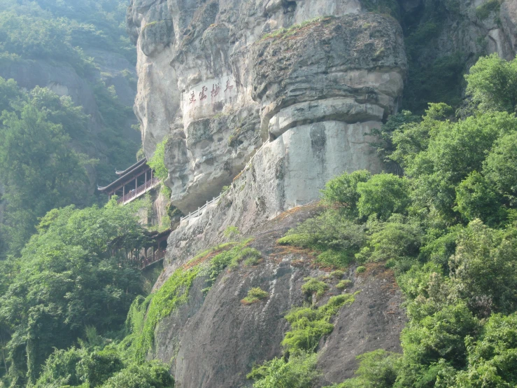 a large cliff with a house built in it