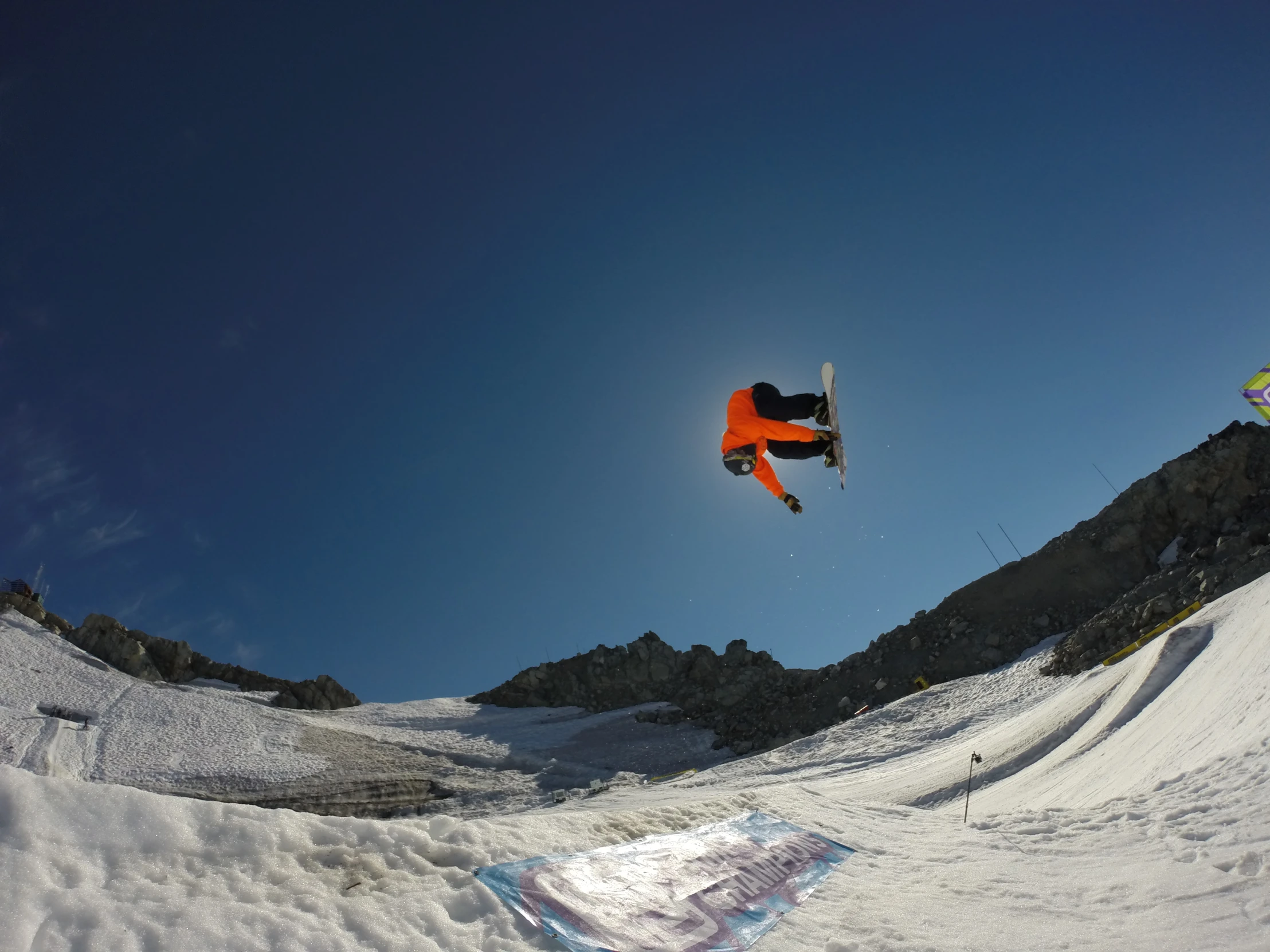 the man is jumping over a snowy mountain on his skis