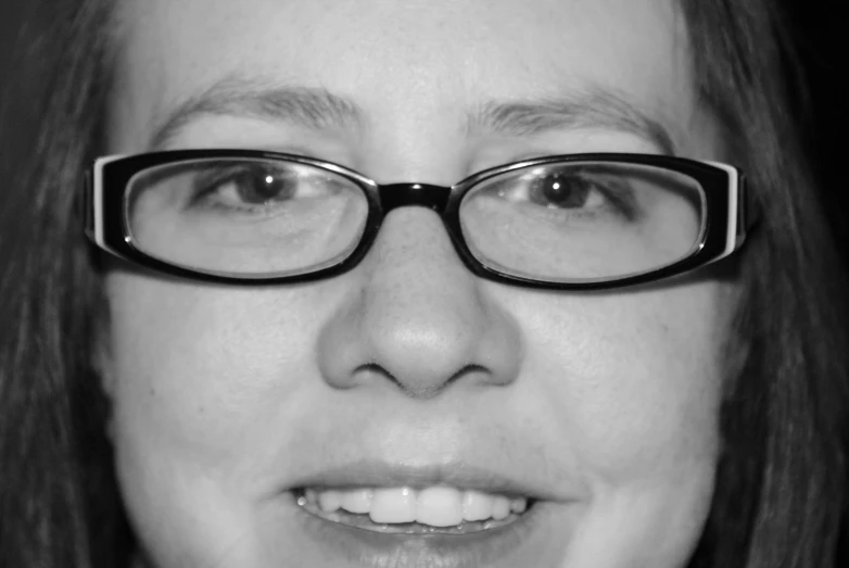 a black and white po of a woman's face with glasses